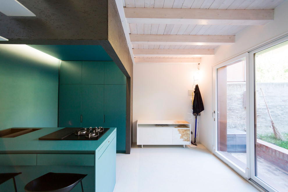 Réalisation d'une petite cuisine ouverte parallèle et encastrable design avec un placard à porte plane, des portes de placard bleues, une péninsule, un plan de travail bleu et un sol gris.