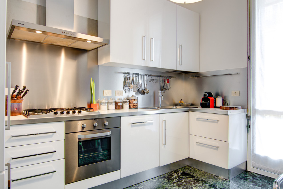 Foto på ett litet funkis beige kök, med en undermonterad diskho, släta luckor, vita skåp, stänkskydd i metallkakel, rostfria vitvaror, målat trägolv och beiget golv