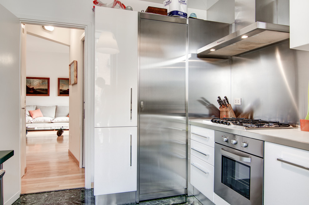 Foto på ett mellanstort funkis beige kök, med en undermonterad diskho, släta luckor, vita skåp, stänkskydd i metallkakel, rostfria vitvaror, marmorgolv och grönt golv