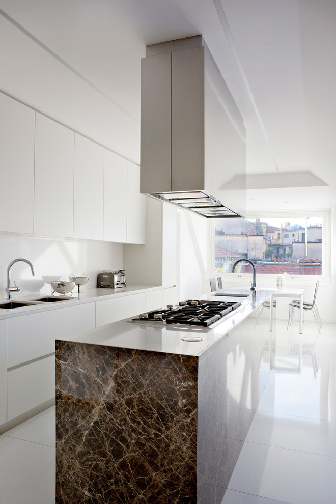Стильный дизайн: прямая кухня в стиле модернизм с обеденным столом, двойной мойкой, плоскими фасадами, белыми фасадами, столешницей из акрилового камня, белым фартуком и островом - последний тренд