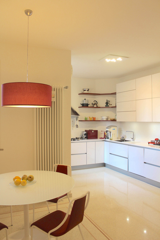 Ispirazione per una cucina moderna con ante lisce, ante bianche, elettrodomestici da incasso, pavimento alla veneziana, pavimento beige e top bianco