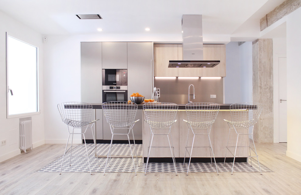 Immagine di una cucina contemporanea con ante lisce, paraspruzzi grigio, elettrodomestici neri, top grigio, ante beige, parquet chiaro e pavimento beige