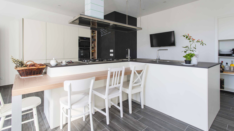 Foto på ett mellanstort funkis kök, med en integrerad diskho, släta luckor, rostfria vitvaror, laminatgolv, flera köksöar och grått golv