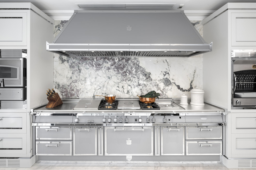 Imagen de cocina tradicional con puertas de armario en acero inoxidable, encimera de acrílico, electrodomésticos de acero inoxidable, suelo de mármol, suelo blanco y encimeras grises