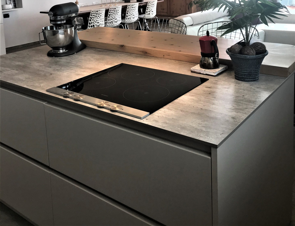 Inredning av ett modernt litet grå linjärt grått kök, med en nedsänkt diskho, luckor med profilerade fronter, vita skåp, bänkskiva i kvarts, grått stänkskydd, stänkskydd i porslinskakel, rostfria vitvaror, klinkergolv i porslin, en köksö och grått golv