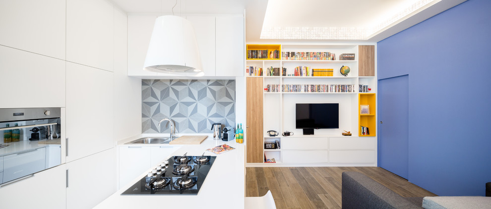 Photo of a medium sized contemporary u-shaped open plan kitchen in Milan with a built-in sink, flat-panel cabinets, white cabinets, engineered stone countertops, white splashback, stainless steel appliances, porcelain flooring, an island and brown floors.