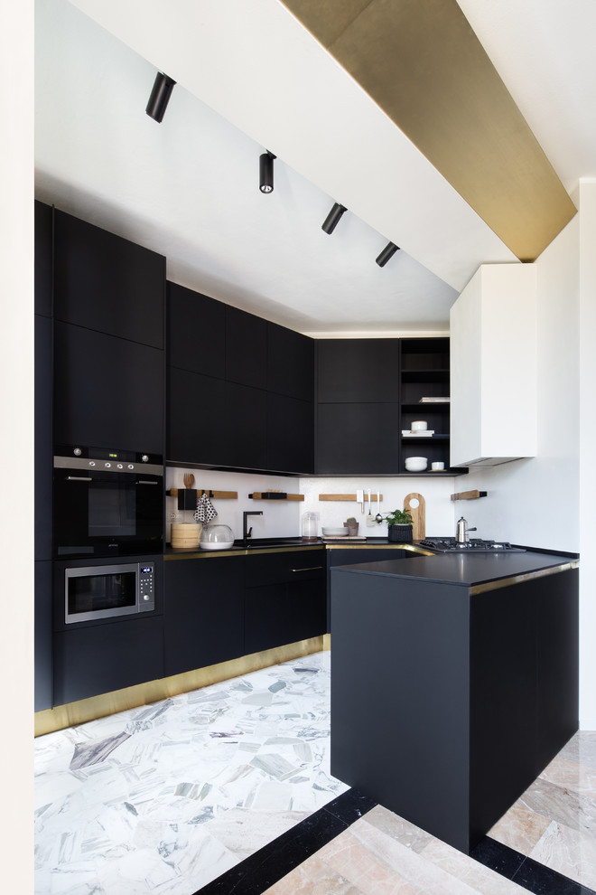 Стильный дизайн: п-образная кухня в современном стиле с плоскими фасадами, черными фасадами, белым фартуком, черной техникой, полуостровом, серым полом и черной столешницей - последний тренд