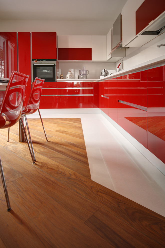 Immagine di una cucina contemporanea di medie dimensioni con ante lisce, ante rosse, pavimento in legno massello medio e nessuna isola
