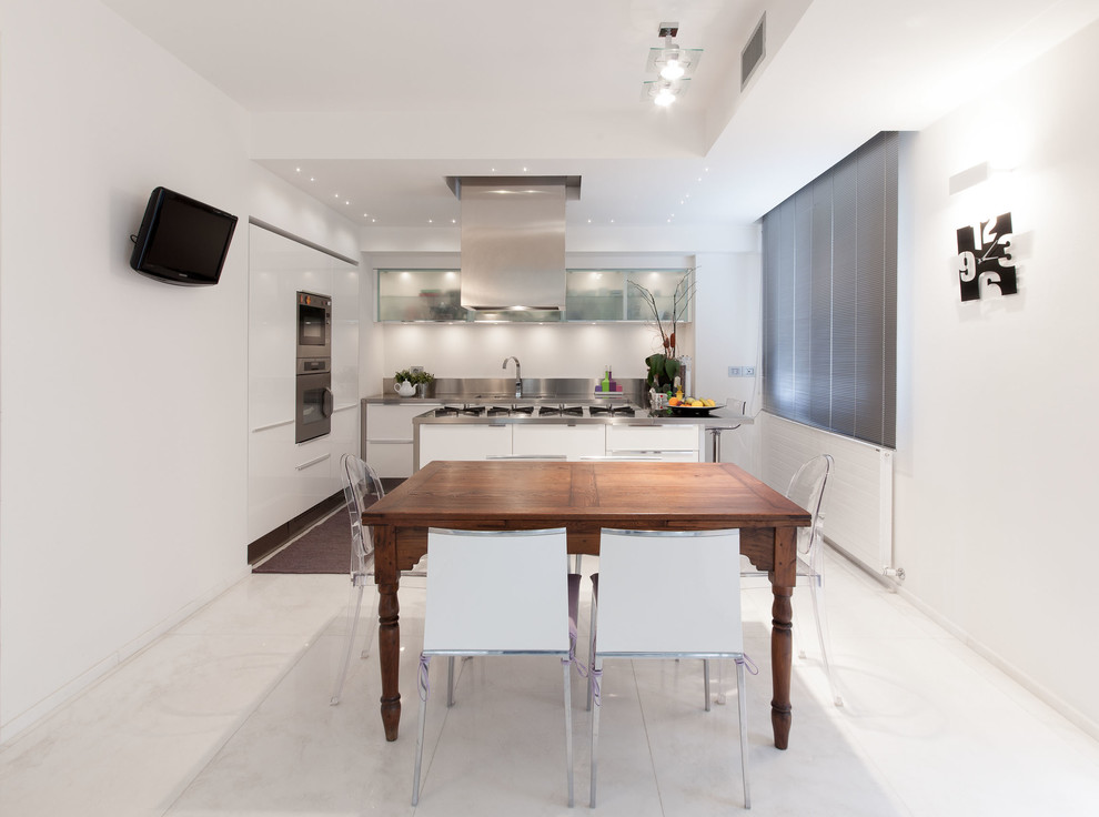 Large contemporary kitchen/diner in Florence with a built-in sink, flat-panel cabinets, white cabinets, stainless steel worktops, metallic splashback, stainless steel appliances and an island.