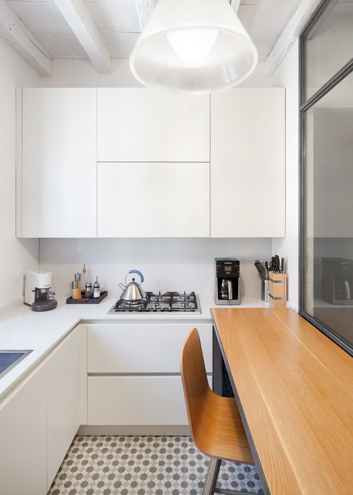 Geschlossene Moderne Küche in U-Form mit Einbauwaschbecken, flächenbündigen Schrankfronten, weißen Schränken, Halbinsel und weißem Boden in Mailand