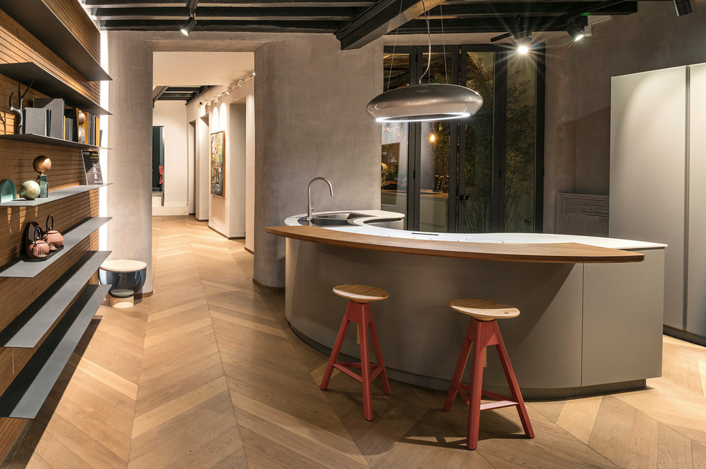 Esempio di un cucina con isola centrale design con lavello a doppia vasca, ante grigie, parquet chiaro e pavimento marrone