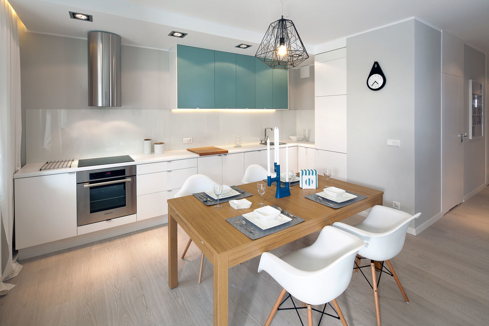 Esempio di una cucina moderna di medie dimensioni con ante bianche, top in quarzo composito, parquet chiaro e pavimento grigio