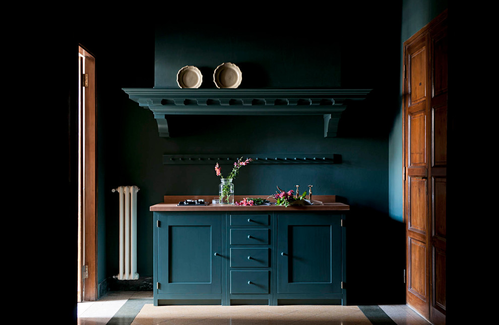 Imagen de cocina lineal clásica con armarios estilo shaker, puertas de armario azules y encimera de madera