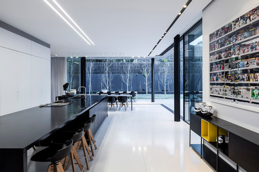 На фото: огромная кухня в стиле модернизм с обеденным столом и черными фасадами