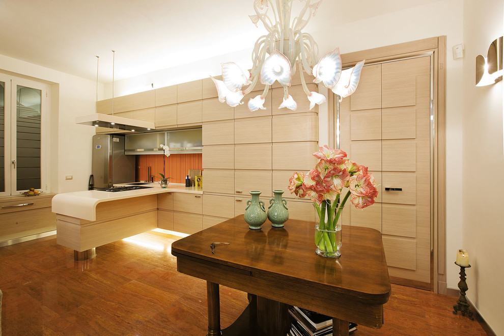Modern inredning av ett stort linjärt kök och matrum, med släta luckor, skåp i ljust trä, rostfria vitvaror och en halv köksö
