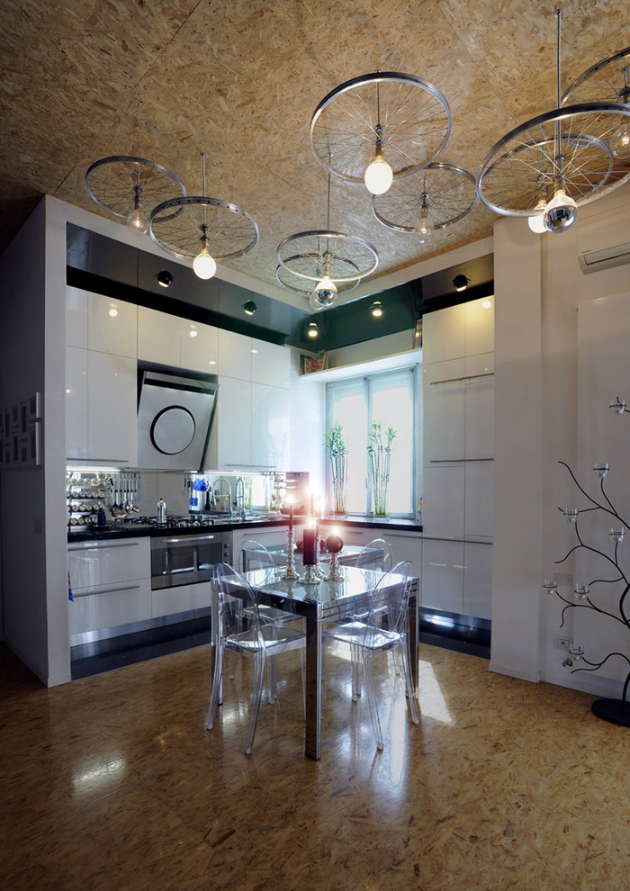 Imagen de cocinas en L contemporánea abierta con armarios con paneles lisos, puertas de armario blancas y electrodomésticos de acero inoxidable