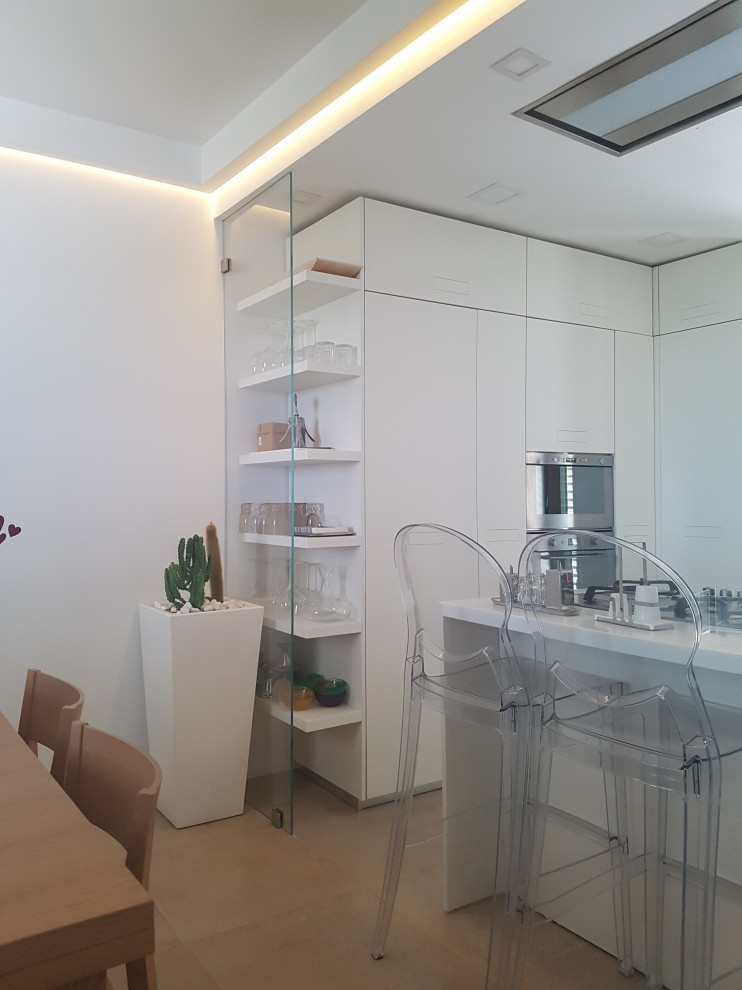 Foto de cocina moderna pequeña con armarios con paneles lisos, puertas de armario blancas, encimera de acrílico, salpicadero blanco, una isla y encimeras blancas