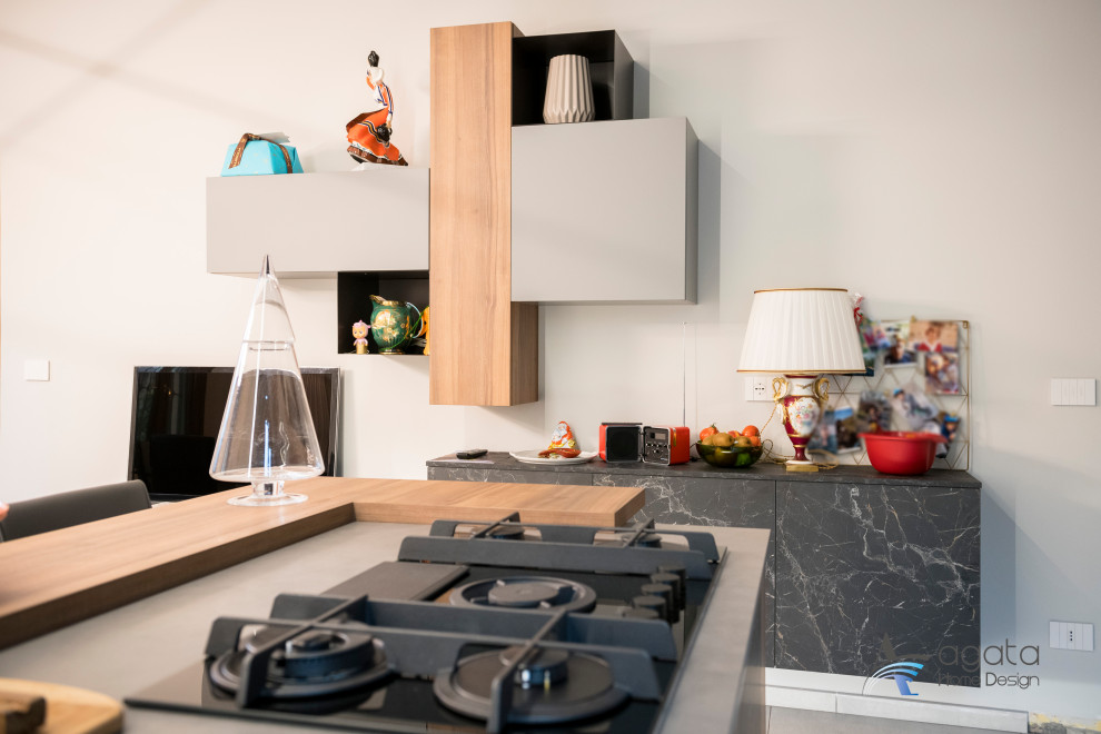 Zweizeilige, Mittelgroße Moderne Wohnküche mit Doppelwaschbecken, schwarzen Elektrogeräten, Porzellan-Bodenfliesen, Kücheninsel und grauem Boden in Turin