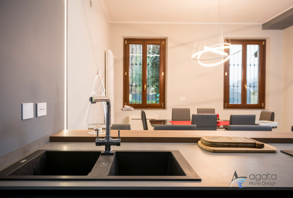 Esempio di una cucina moderna di medie dimensioni con lavello a doppia vasca, elettrodomestici neri, pavimento in gres porcellanato e pavimento grigio