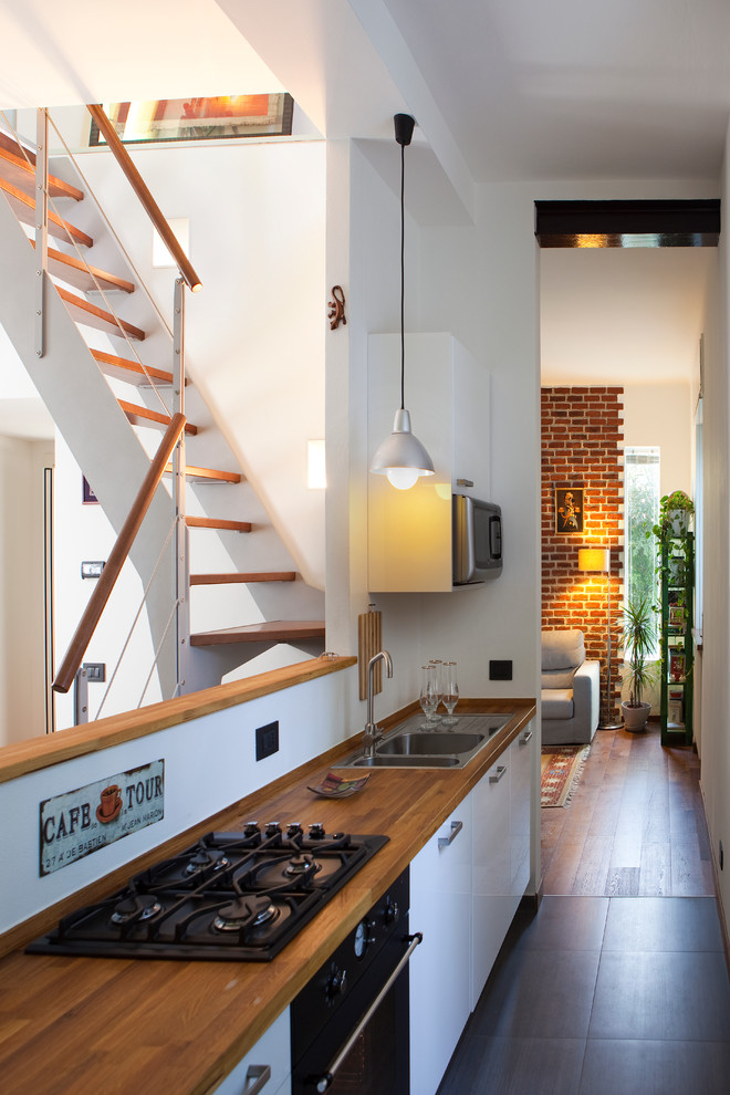 Стильный дизайн: параллельная кухня среднего размера в стиле модернизм с обеденным столом, плоскими фасадами, деревянной столешницей и полом из керамогранита - последний тренд