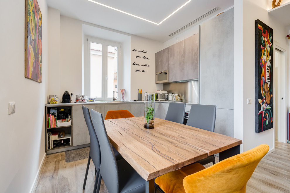 Eat-in kitchen - mid-sized contemporary l-shaped porcelain tile and beige floor eat-in kitchen idea in Rome with flat-panel cabinets, gray cabinets, gray backsplash and stainless steel appliances