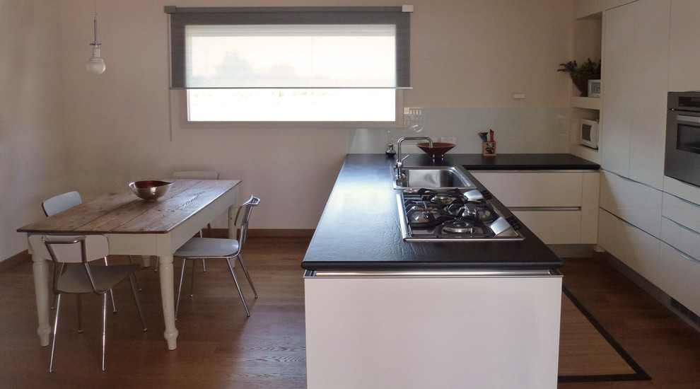Offene, Große Moderne Küche in L-Form mit flächenbündigen Schrankfronten, hellen Holzschränken, braunem Holzboden, Kücheninsel und braunem Boden in Sonstige