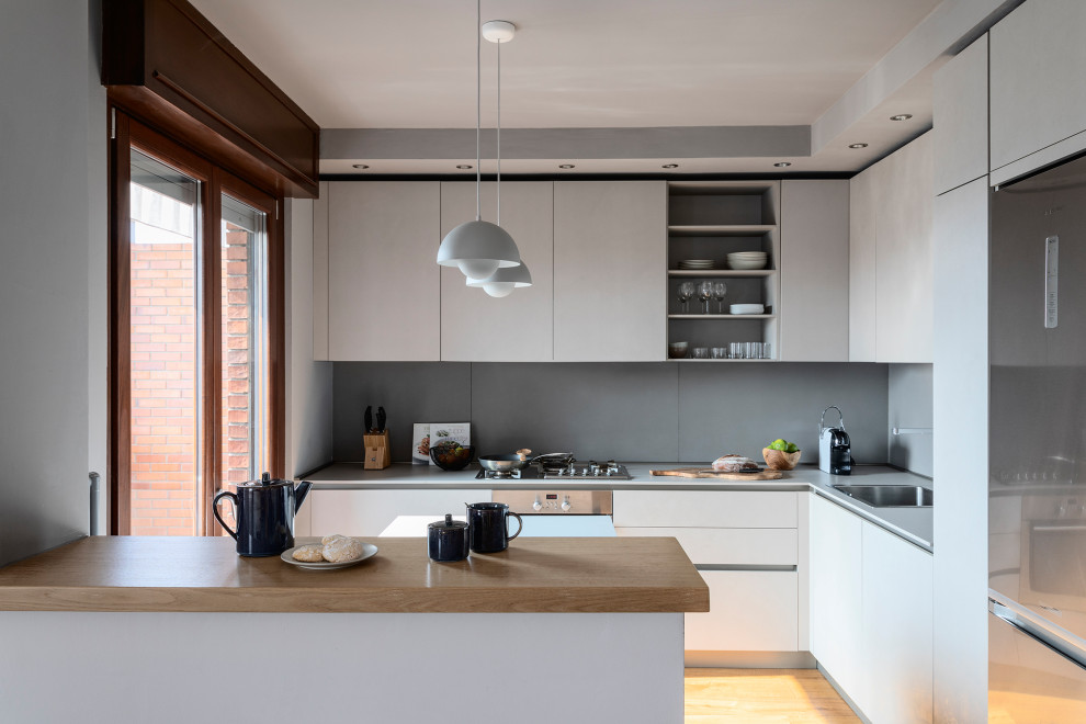 Idee per una cucina design di medie dimensioni con ante lisce, ante grigie, top in laminato, parquet chiaro e top grigio