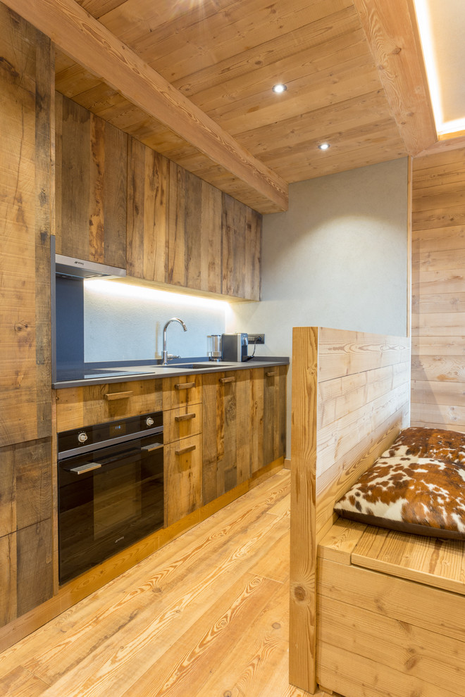 Idee per una cucina stile rurale con pavimento in legno massello medio, nessuna isola, ante lisce, ante in legno bruno, pavimento marrone e top grigio