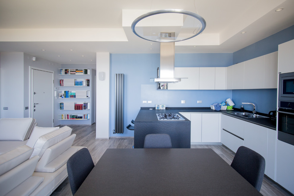 Immagine di una cucina ad ambiente unico stile marinaro con ante bianche, top in quarzite e pavimento in gres porcellanato