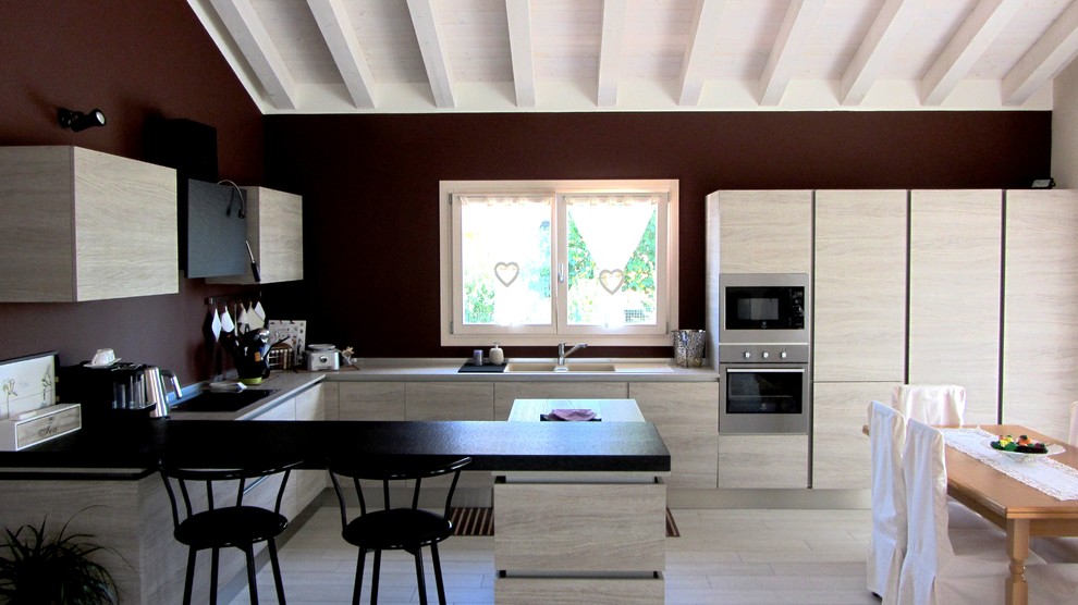 Idée de décoration pour une cuisine ouverte linéaire design avec un placard avec porte à panneau encastré, un sol en linoléum et îlot.