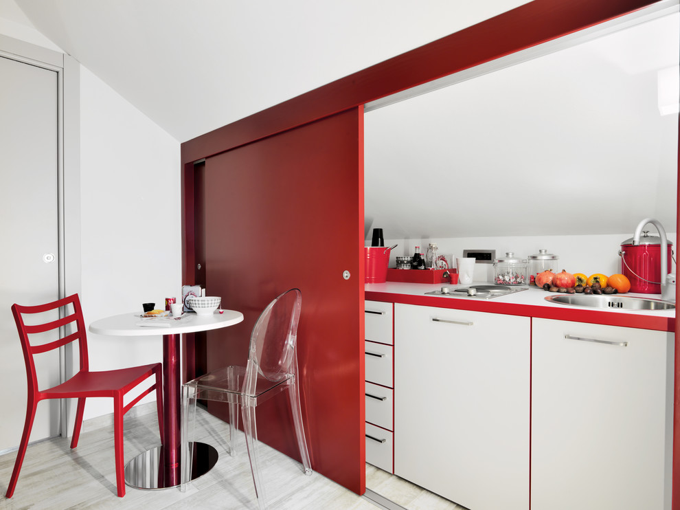 This is an example of a small contemporary single-wall enclosed kitchen in Turin with a built-in sink, flat-panel cabinets, white cabinets, laminate countertops, porcelain flooring, white splashback, no island and grey floors.