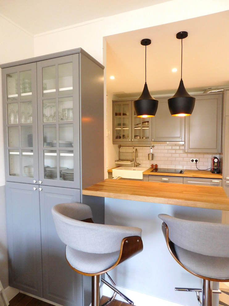 Inspiration for a medium sized industrial kitchen/diner in Other with a single-bowl sink, raised-panel cabinets, grey cabinets, wood worktops, white splashback, ceramic splashback, stainless steel appliances, dark hardwood flooring and an island.