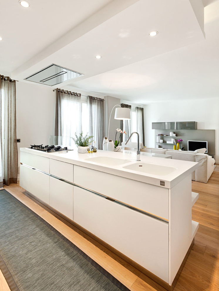 Immagine di una cucina contemporanea di medie dimensioni con lavello integrato, ante lisce, ante bianche, pavimento in legno massello medio e pavimento marrone
