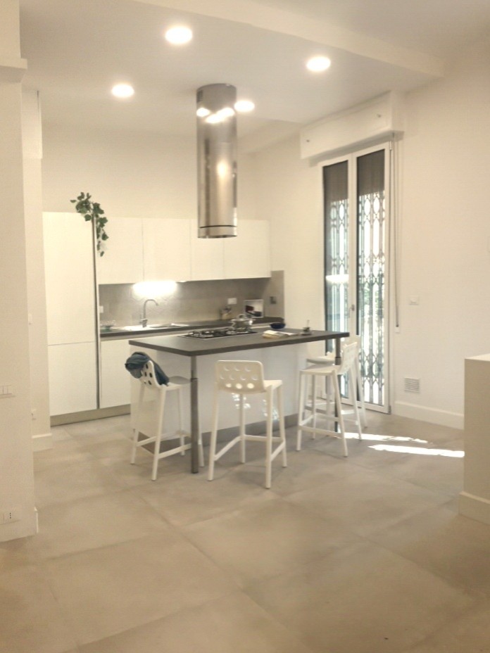 Idee per una cucina design di medie dimensioni con lavello da incasso, ante lisce, ante bianche, top in laminato, paraspruzzi beige, paraspruzzi in gres porcellanato, elettrodomestici in acciaio inossidabile, pavimento in gres porcellanato, pavimento beige e top marrone