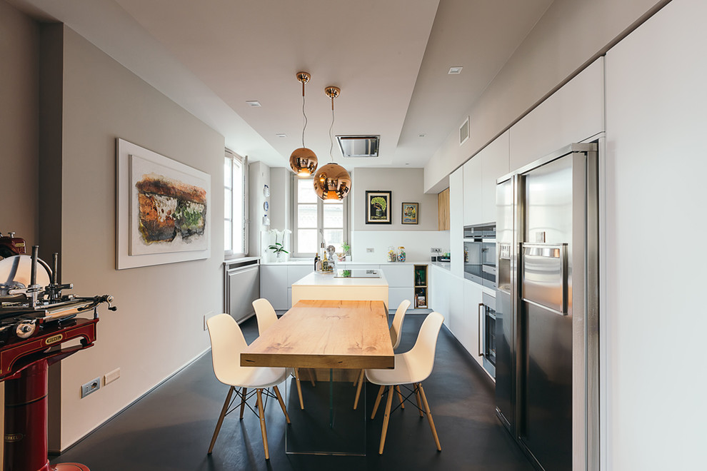 Foto di una cucina contemporanea con ante lisce, ante bianche, paraspruzzi bianco, elettrodomestici in acciaio inossidabile, pavimento nero e top bianco