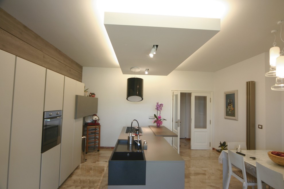 フィレンツェにある広いコンテンポラリースタイルのおしゃれなキッチン (ダブルシンク、フラットパネル扉のキャビネット、クオーツストーンカウンター、シルバーの調理設備、大理石の床、マルチカラーの床) の写真