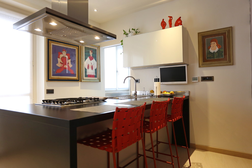 Immagine di una cucina abitabile minimal di medie dimensioni con lavello da incasso, ante lisce, ante grigie, elettrodomestici in acciaio inossidabile e penisola