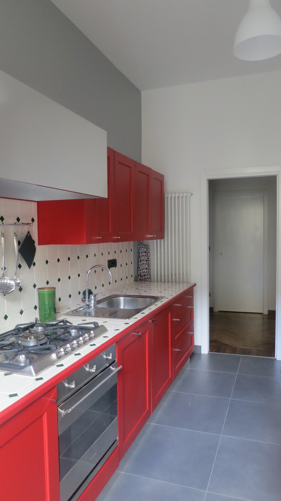 Cette image montre une petite cuisine parallèle traditionnelle avec un évier 2 bacs, des portes de placard rouges, plan de travail carrelé, une crédence beige, une crédence en céramique, un électroménager blanc, un sol en carrelage de céramique et un sol gris.