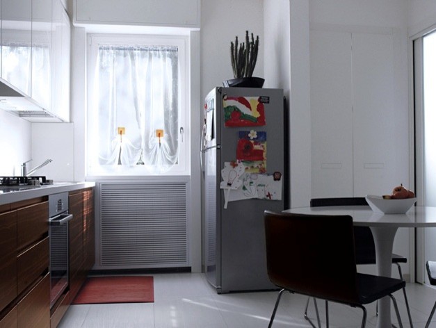 Foto di una cucina minimalista di medie dimensioni con pavimento in gres porcellanato, paraspruzzi bianco, elettrodomestici in acciaio inossidabile, nessuna isola e top bianco