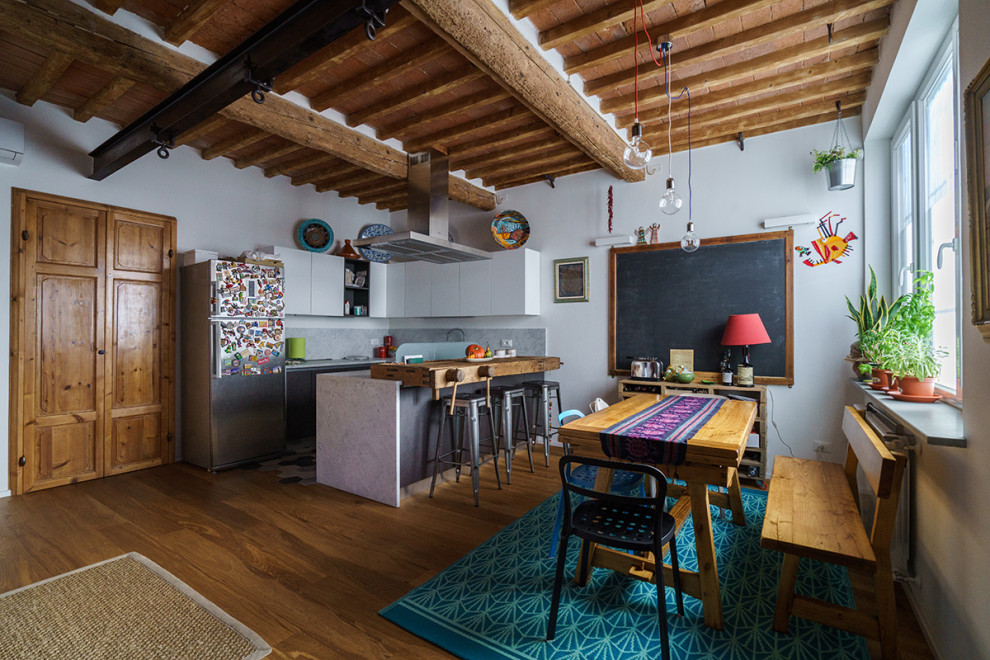 フィレンツェにある高級な巨大なエクレクティックスタイルのおしゃれなキッチン (茶色い床、フラットパネル扉のキャビネット、白いキャビネット、シルバーの調理設備、無垢フローリング、グレーのキッチンカウンター) の写真