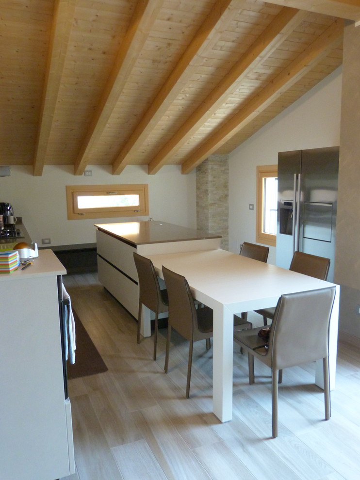 Cette image montre une cuisine ouverte parallèle rustique de taille moyenne avec un sol en carrelage de porcelaine, îlot et un sol beige.
