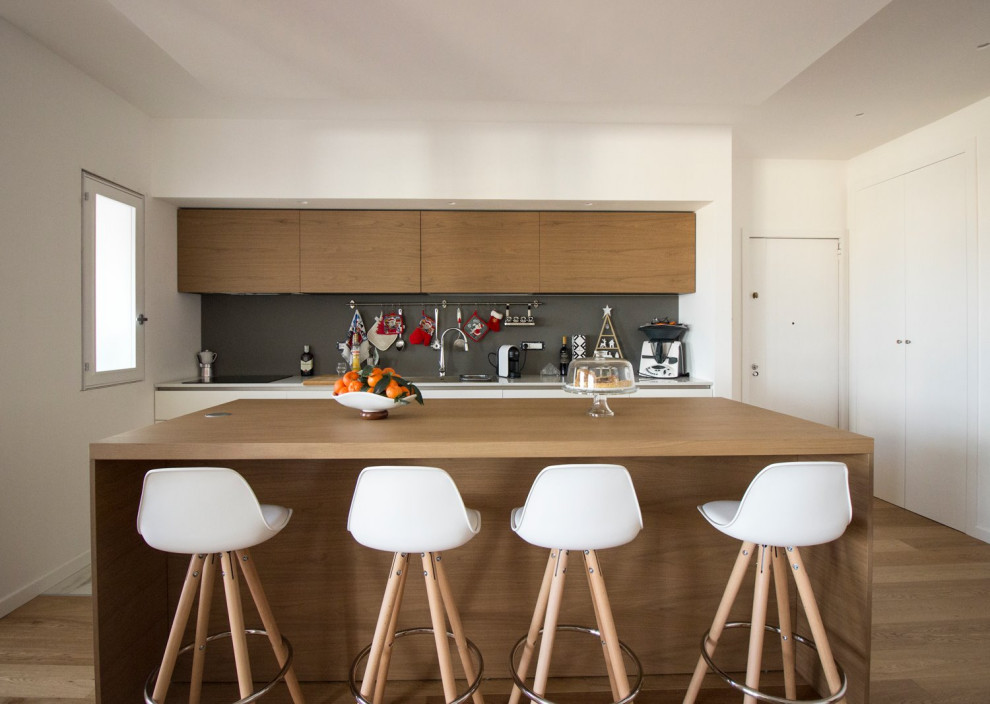 Esempio di un cucina con isola centrale minimal con ante lisce, ante marroni, paraspruzzi grigio e pavimento marrone