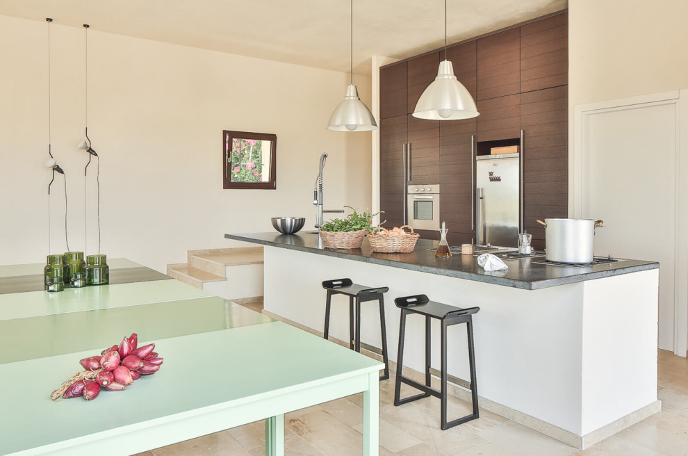 Exemple d'une cuisine parallèle tendance en bois foncé avec un placard à porte plane, îlot, un sol beige et un plan de travail gris.