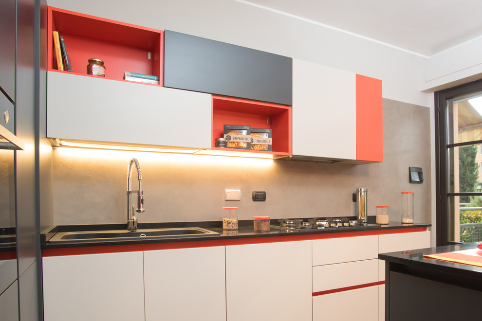 Design ideas for a medium sized contemporary l-shaped enclosed kitchen in Florence with a single-bowl sink, flat-panel cabinets, beige cabinets, granite worktops, grey splashback, stone slab splashback, black appliances, concrete flooring and an island.