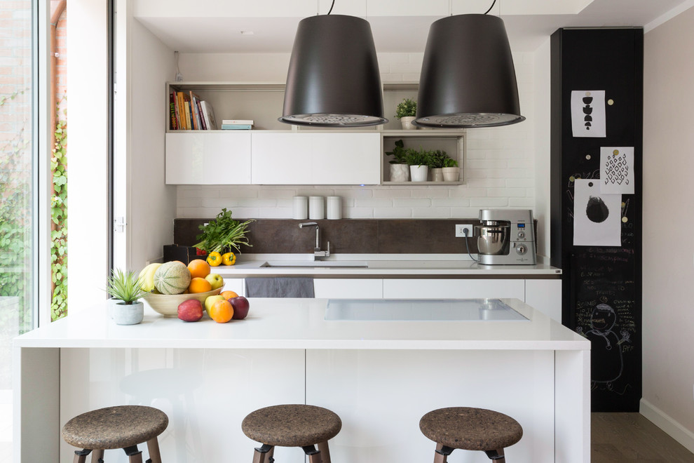 Design ideas for a contemporary single-wall kitchen in Other with a submerged sink, flat-panel cabinets, white cabinets, grey splashback, an island and white worktops.