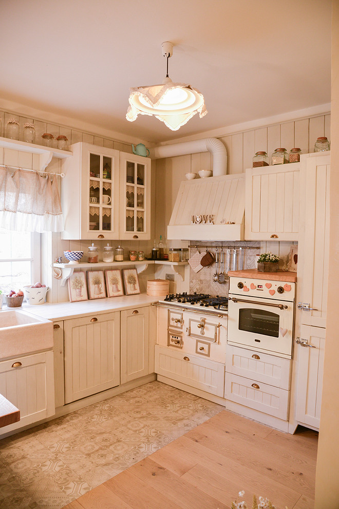 Foto de cocinas en U romántico pequeño cerrado sin isla con armarios con paneles con relieve y puertas de armario beige