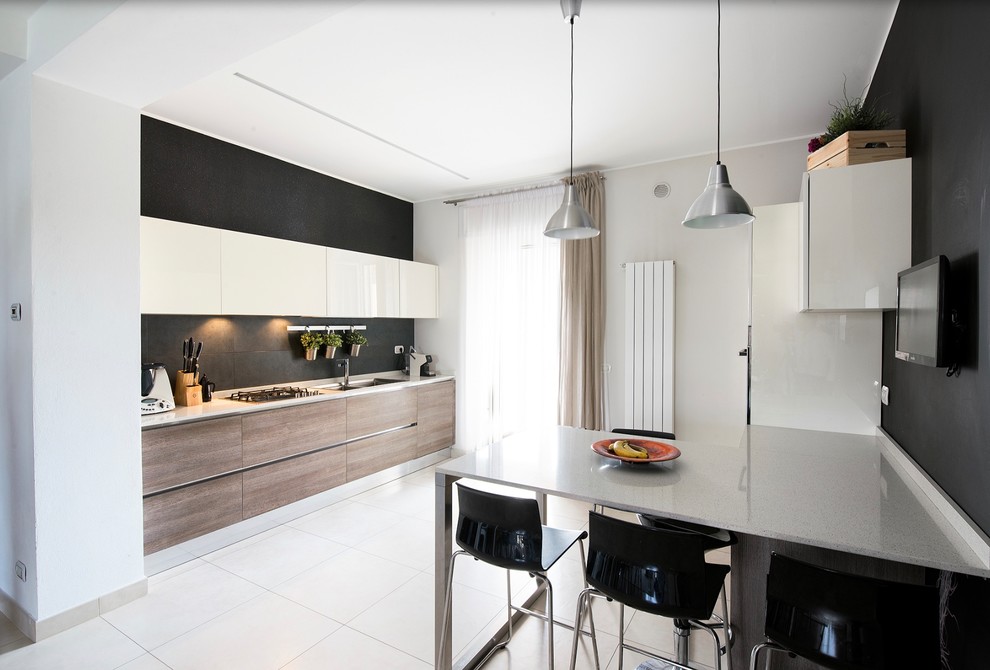 Diseño de cocina contemporánea con fregadero de doble seno, armarios con paneles lisos, puertas de armario de madera oscura, salpicadero negro, península y suelo blanco