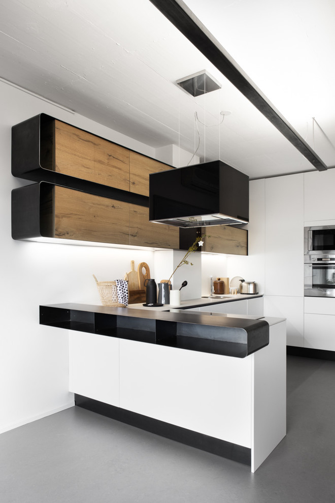 Immagine di una cucina contemporanea di medie dimensioni con ante lisce, pavimento in cemento, penisola e pavimento grigio