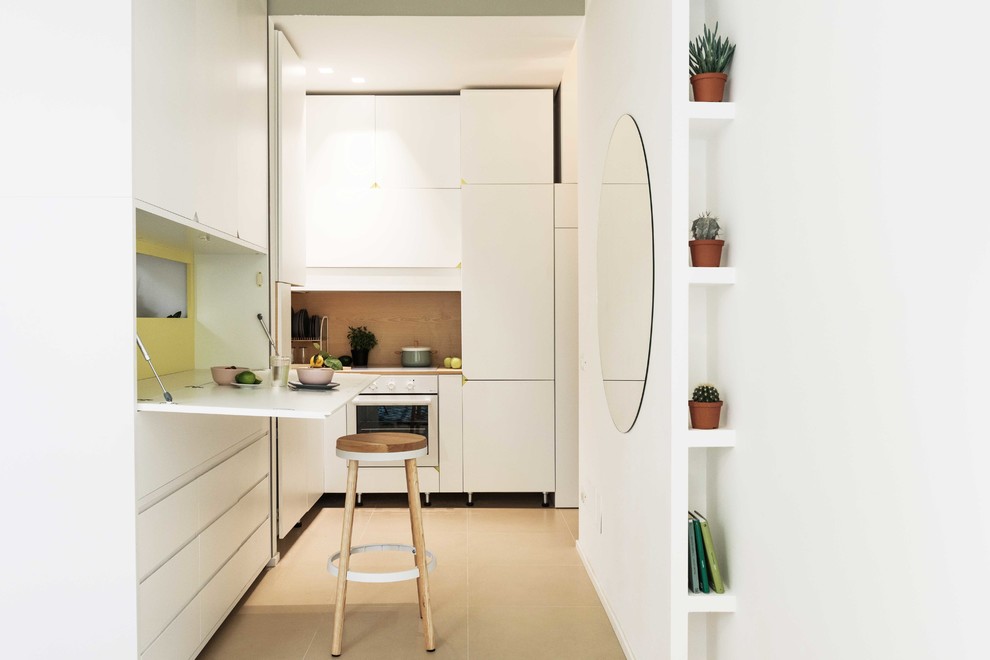 На фото: маленькая угловая кухня-гостиная в современном стиле с плоскими фасадами и белыми фасадами без острова для на участке и в саду с