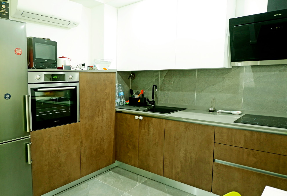 Photo of a medium sized contemporary l-shaped enclosed kitchen in Other with a built-in sink, flat-panel cabinets, brown cabinets, porcelain splashback, stainless steel appliances, porcelain flooring, grey floors and grey worktops.